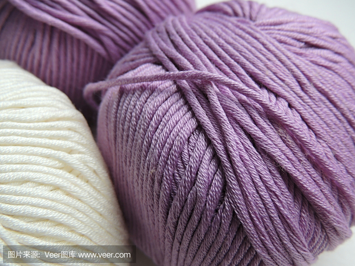 编织用白色和淡紫色的棉纱球。
