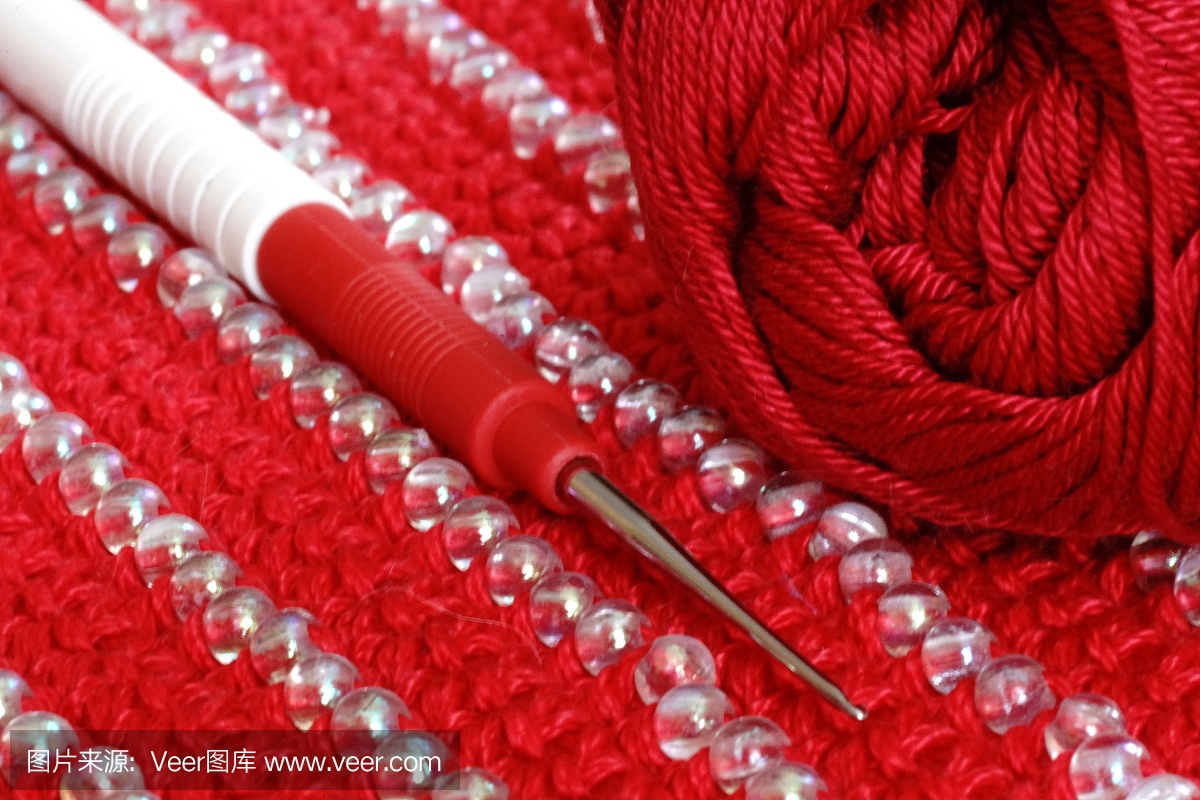 用钩针钩在带有装饰的红色针织物上
